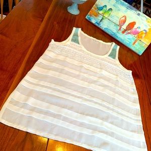 Sleeveless white and pastel blouse.